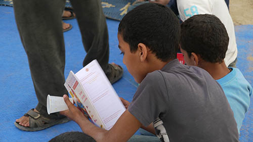 enfant lisant lors d'un projet d'art de rue Nawak Production