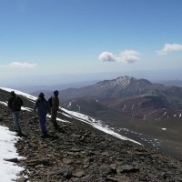 Des randonneurs contemplent le paysage lors de l'ascension du M'Goun : des collines rocailleuses saupoudrées de neige.