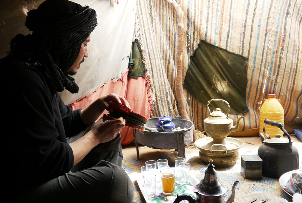 Un homme prépare le thé marocain lors du séjour méharée dans le désert en famille